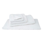 Folded white cotton bath towels and bath mat for hotels