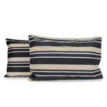 Pair of Brighton Stripe pillowcases featuring horizontal white and beige printed stripes on a charcoal grey geometric diamond print background with tailored edges, fitted over pillows on a white background.
