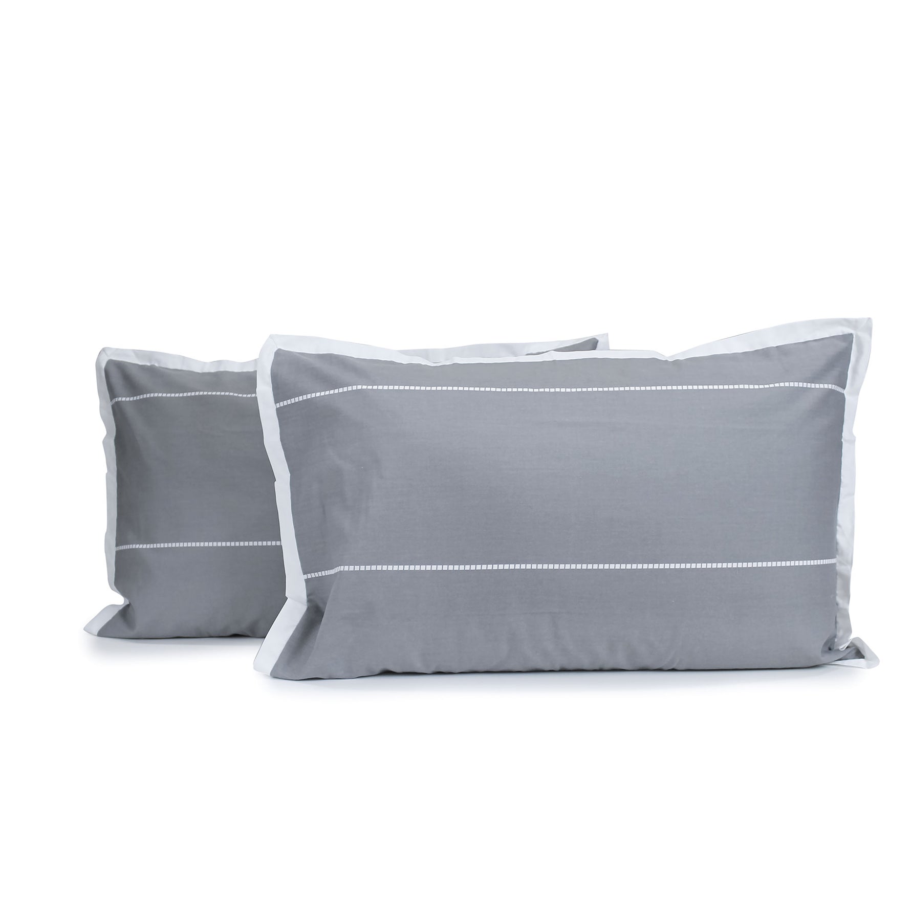 Pair of granite grey and white Calista pillowcases with white horizontal dashed stripes and white tailored edges, fitted over pillows on a white background.
