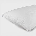 White CoolMax waterproof pillow protector with zip closure fitted over a pillow on a white background.
