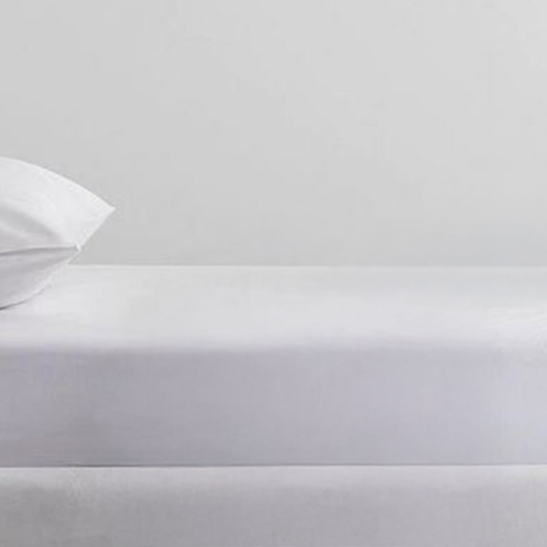 White Cotton Deluxe cotton percale fitted sheet on a mattress with a pillow in a matching pillowcase.