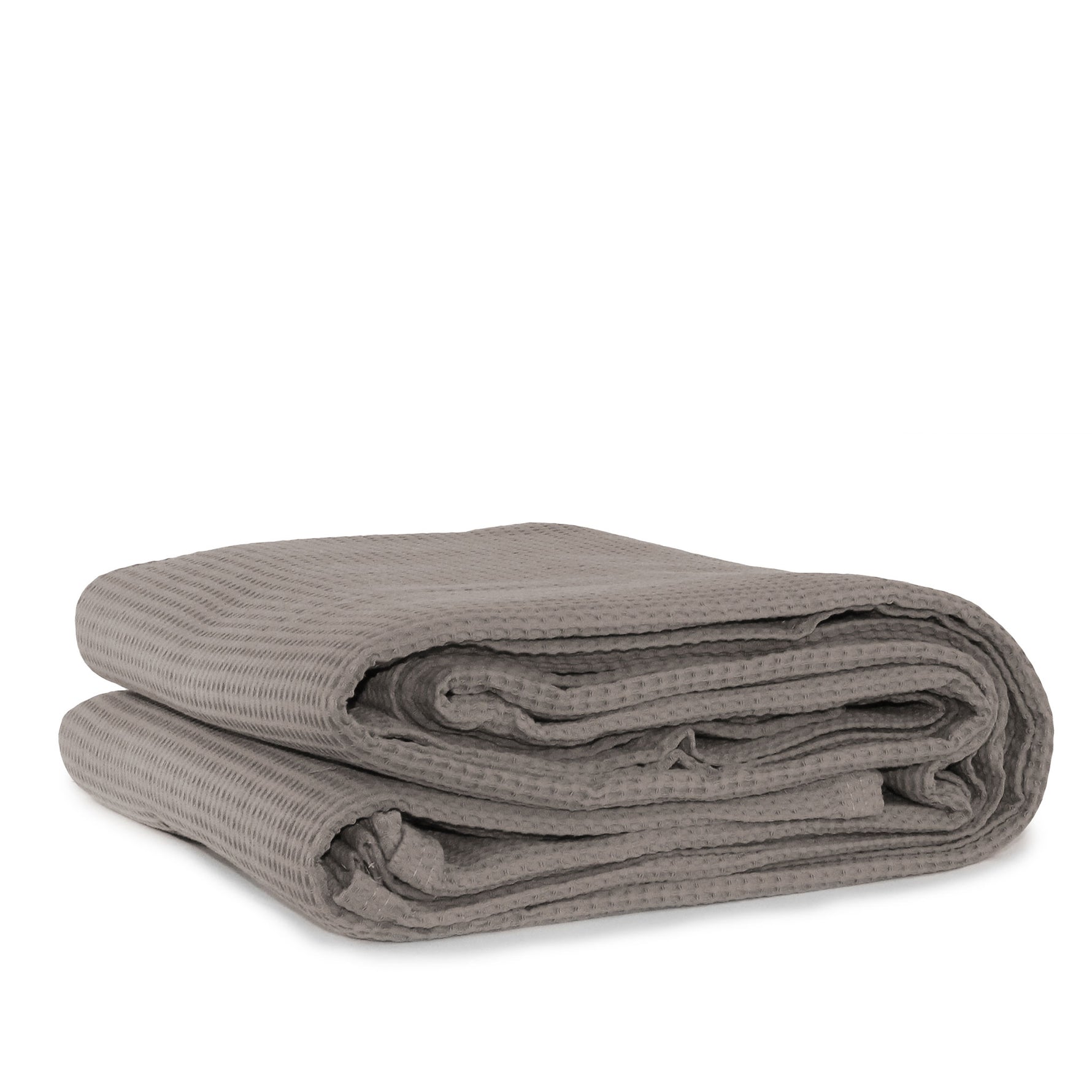 A folded latte cotton waffle blanket on a white background.