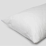 A white, Heavenly Dreams quilted cotton pillow protector with a zipper closure.