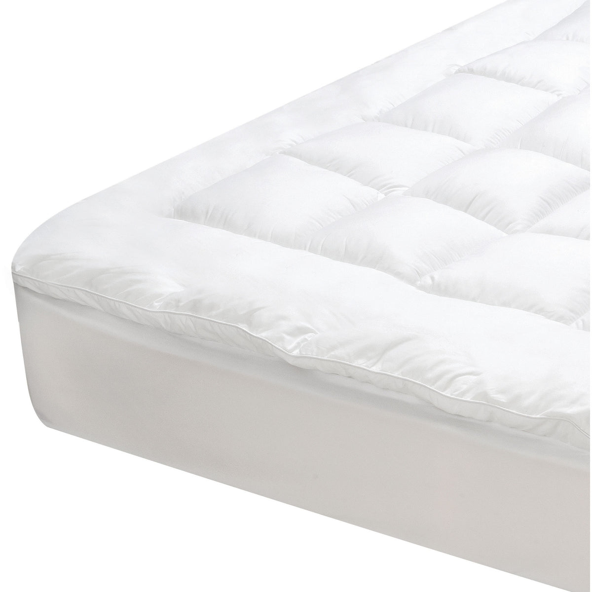 Close-up of a white J-Dream gusseted mattress topper with a square-quilted centre panel, smooth border, gusseted sidewall and fitted skirt over a mattress corner.