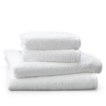 Stacked white terry towels in four sizes on a white background.