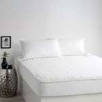 Electric blanket on a bed with two controllers, paired with two plain pillows without covers, offering a warm and comfortable sleep experience. Ideal for cosy nights with adjustable warmth.