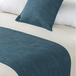 Marine blue linen-look bed runner and matching cushion displayed on a bed with white bedding.