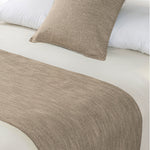 Sand beige linen-look bed runner and matching cushion displayed on a bed with white bedding.