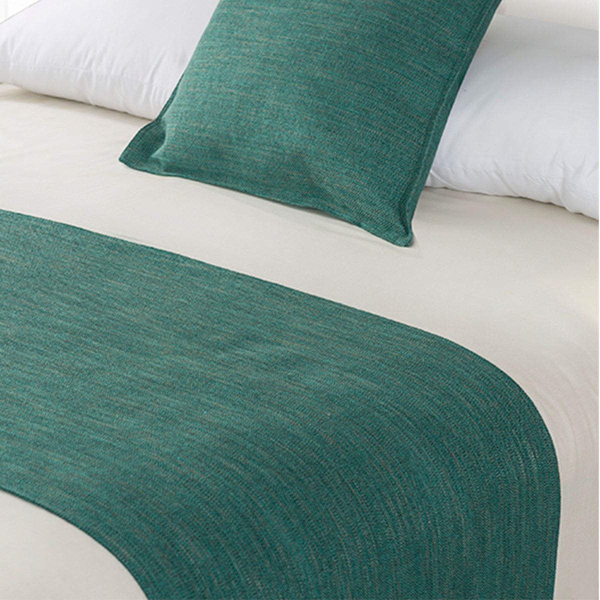 Teal green linen-look bed runner and matching cushion displayed on a bed with white bedding.