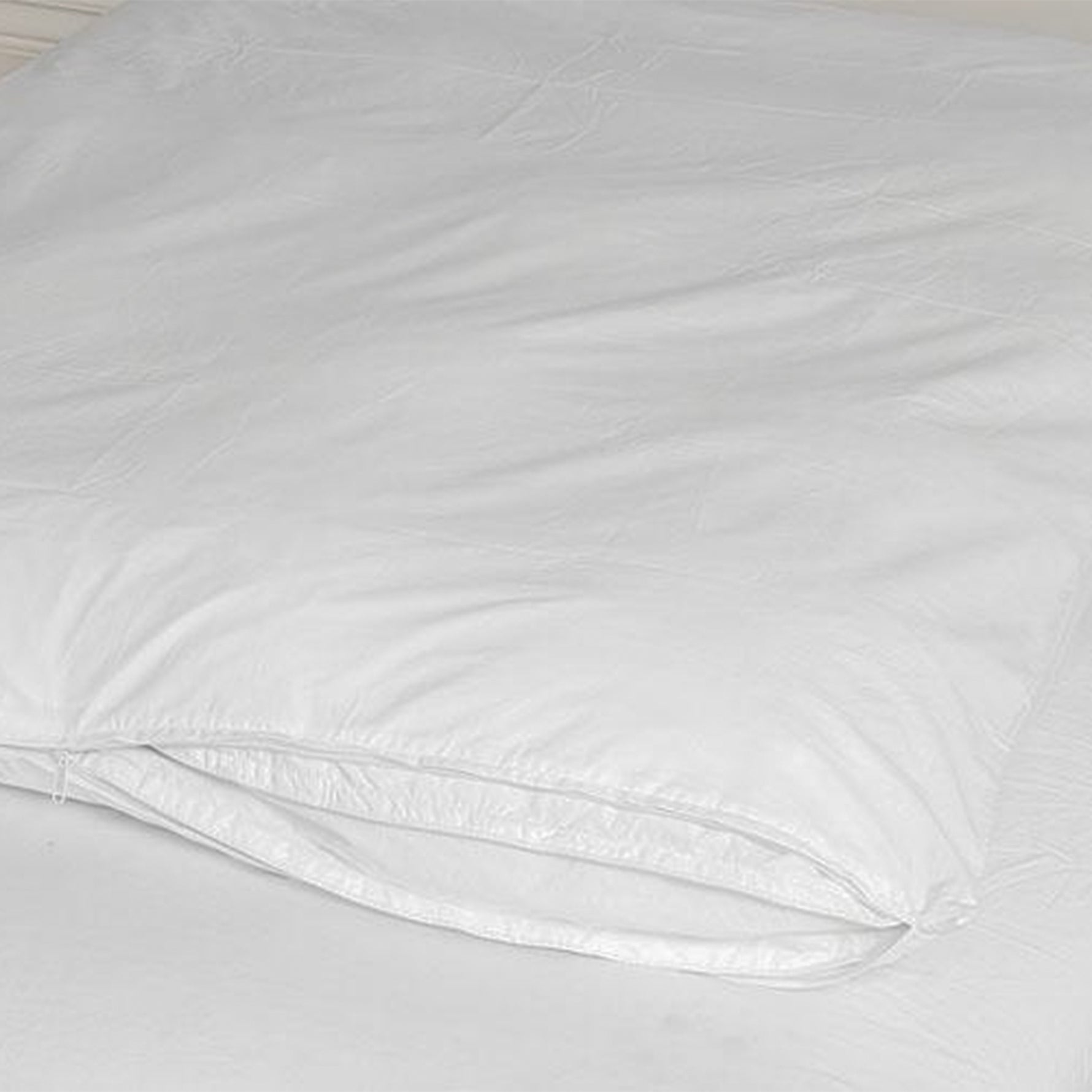 White Micro Fresh stain-resistant quilt protector fitted over a quilt, showing the open end on a bed.