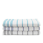 Stacked white terry pool towels with steel grey, ink blue and turquoise blue horizontal stripe details on a white background.
