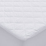 White waterproof Repreve mattress protector with diamond quilting and fitted skirt on a mattress corner.