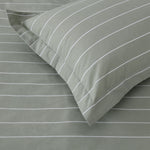 Close up of Studio Stripe pillowcase corner in sage green