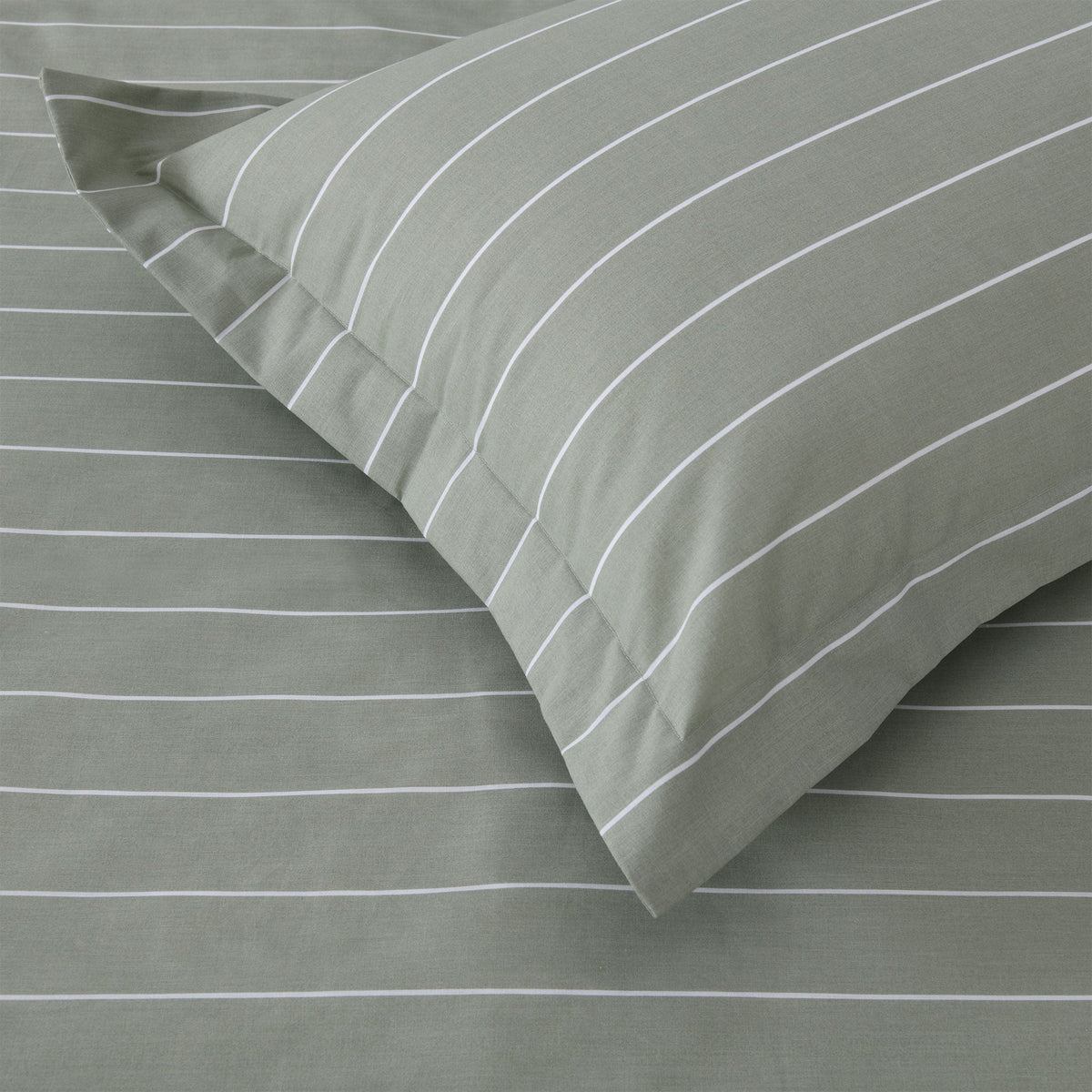 Close up of Studio Stripe pillowcase corner in sage green