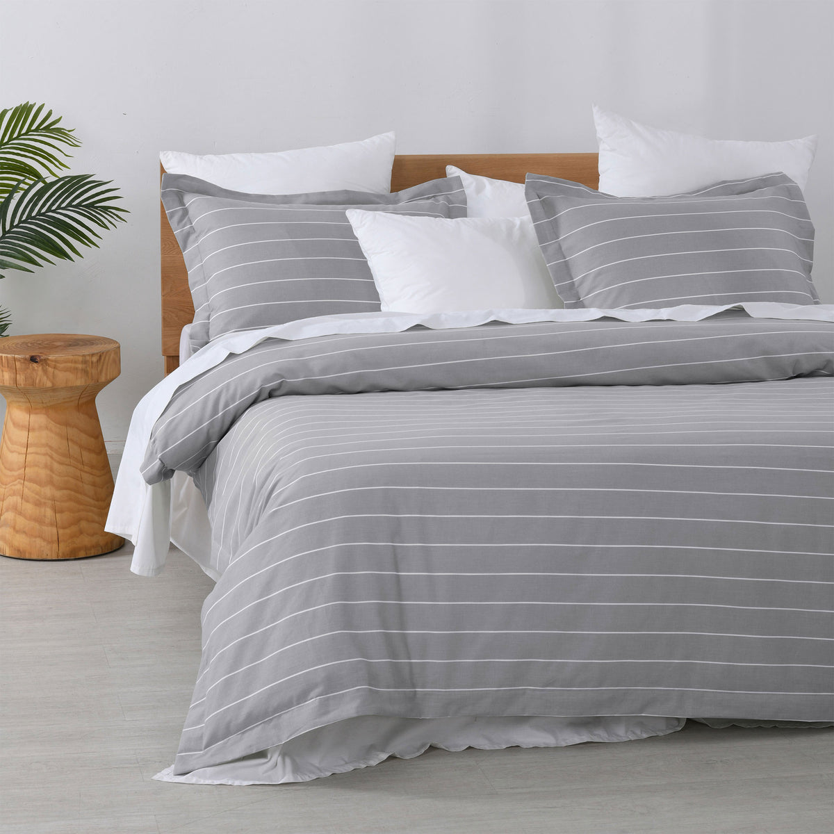 Studio Stripe quilt cover set featuring fine white pinstripes on a silver grey background with matching pillowcases and white pillows on a bed.