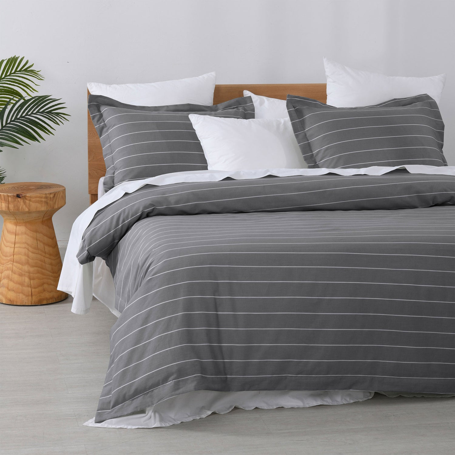 Studio Stripe quilt cover set featuring fine white pinstripes on a slate grey background with matching pillowcases and white pillows on a bed.
